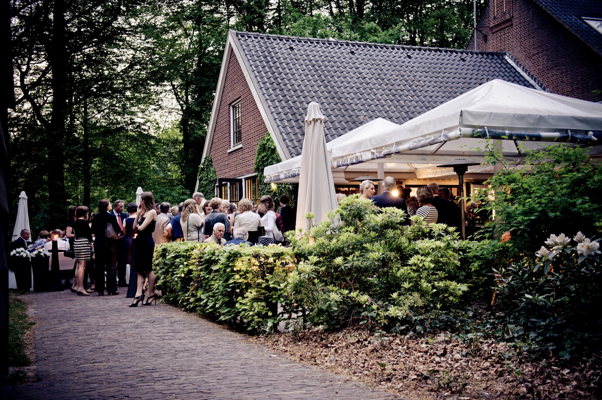 De herberg met terras, omringd door groen
